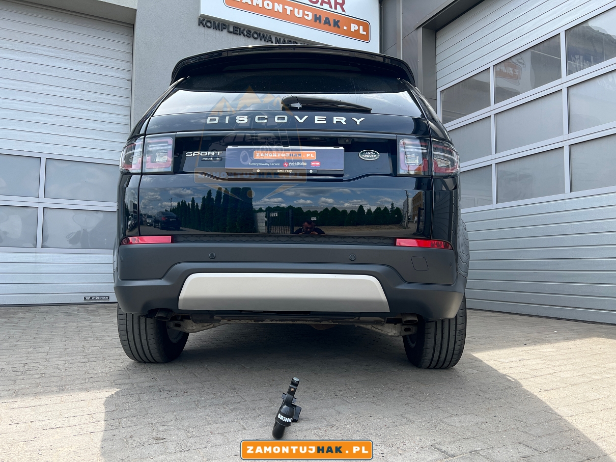 land rover discovery sport L550 2019 hybryda mhev z zdemontowaną kulą holowniczą brink pokazaną na zdjęciu przy samochodzie ktory jest ustawiony na tle najlepszego serwisu samochodowego w poznaniu 